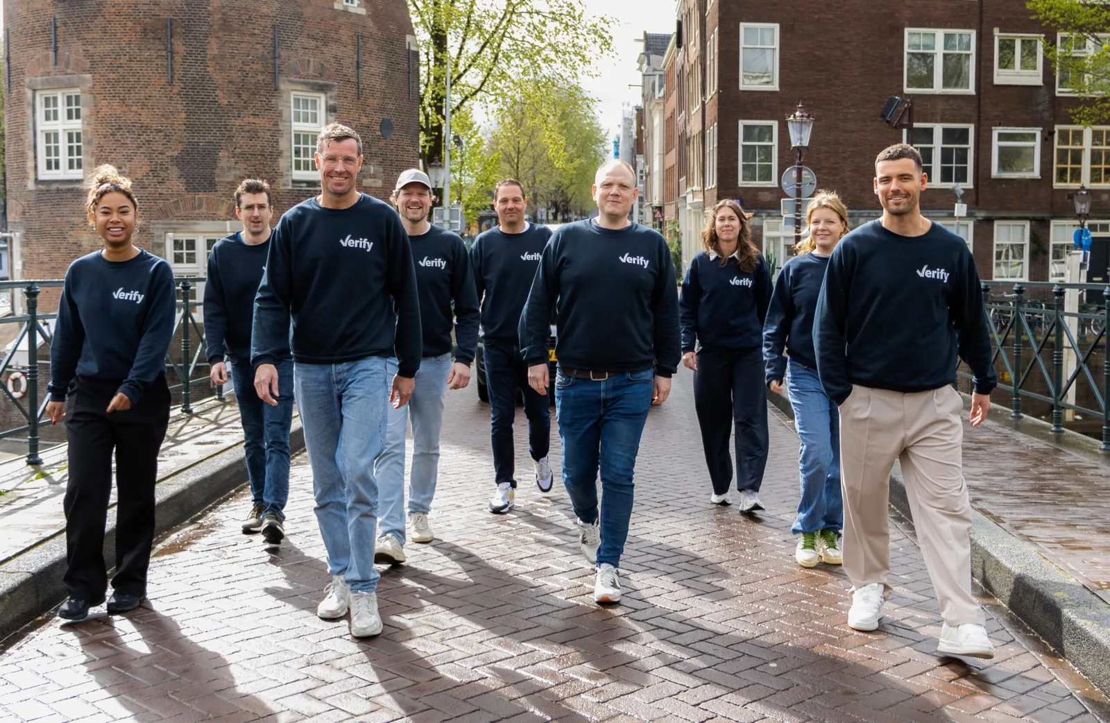 The Verify team walking across a canal bridge in Amsterdam